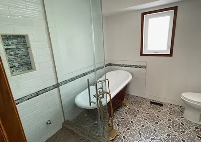 Completed bathroom renovation by My Home Handyman in Calgary, Alberta. Featuring modern fixtures, stylish tile work, and updated vanities, tub and shower with custom glass.